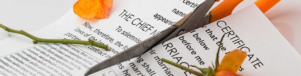 Scissors cutting through a marriage certificate