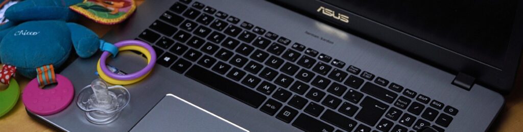 A child's toy keyset lays next to a laptop computer