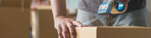 man taping moving box