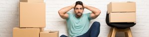 man sitting among moving boxes
