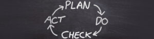 blackboard with plan, do, check, act written in a circle